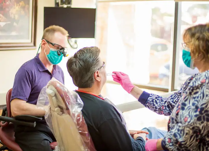 Dr. Walker and team members treating patient at Robert F. Walker Jr. DDS in Chandler, AZ