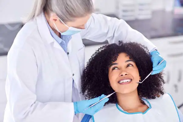 Black woman with curly hair in the dental chair